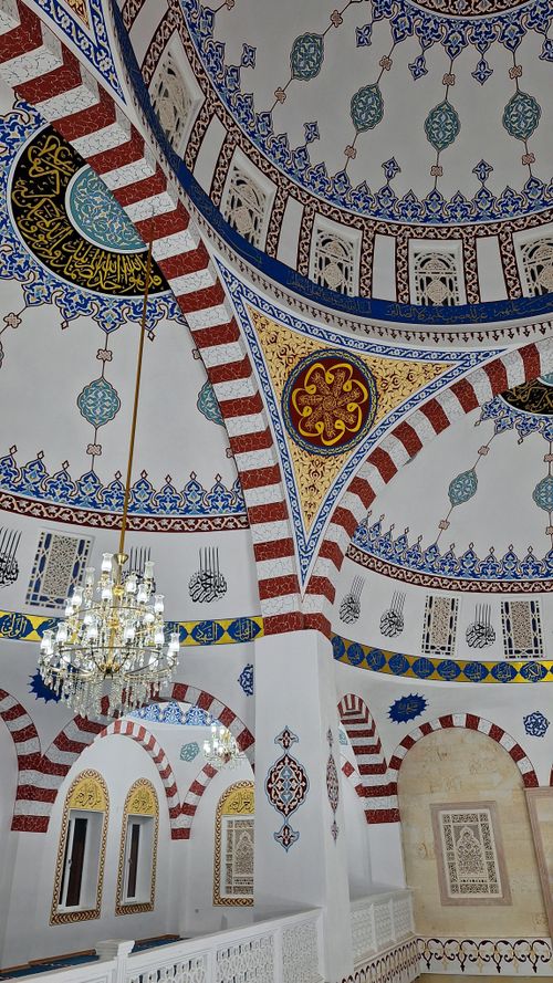 Free A beautifully ornamented mosque interior featuring a chandelier and detailed motifs. Stock Photo
