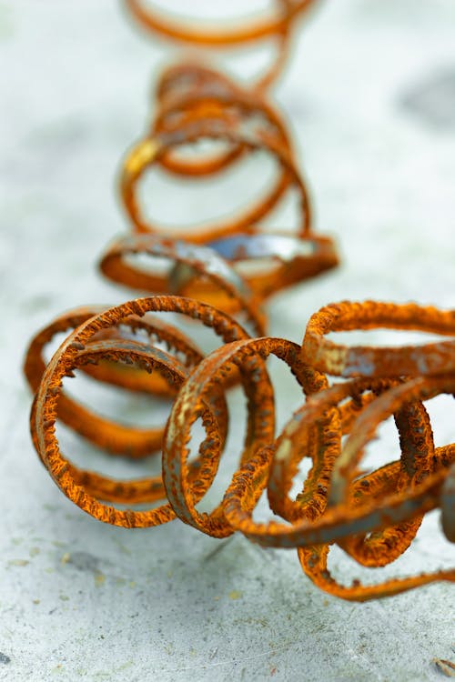 Rusted spiraled metal on bright metal surface