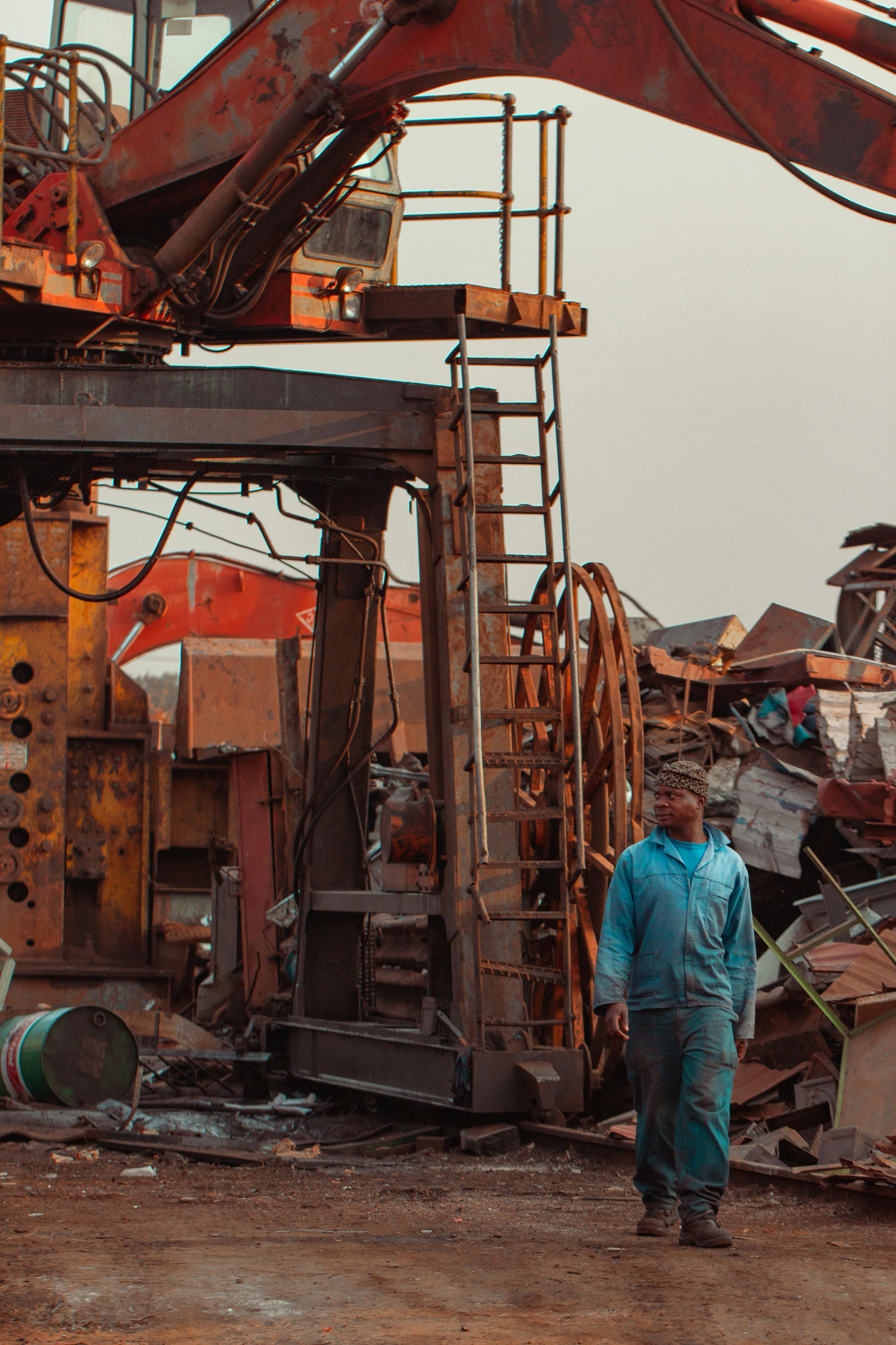 blue collar working walking through scrapyard in uniform