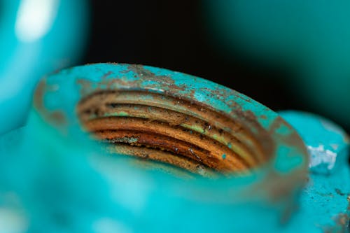 Bright blue screw contrasted with orange rust