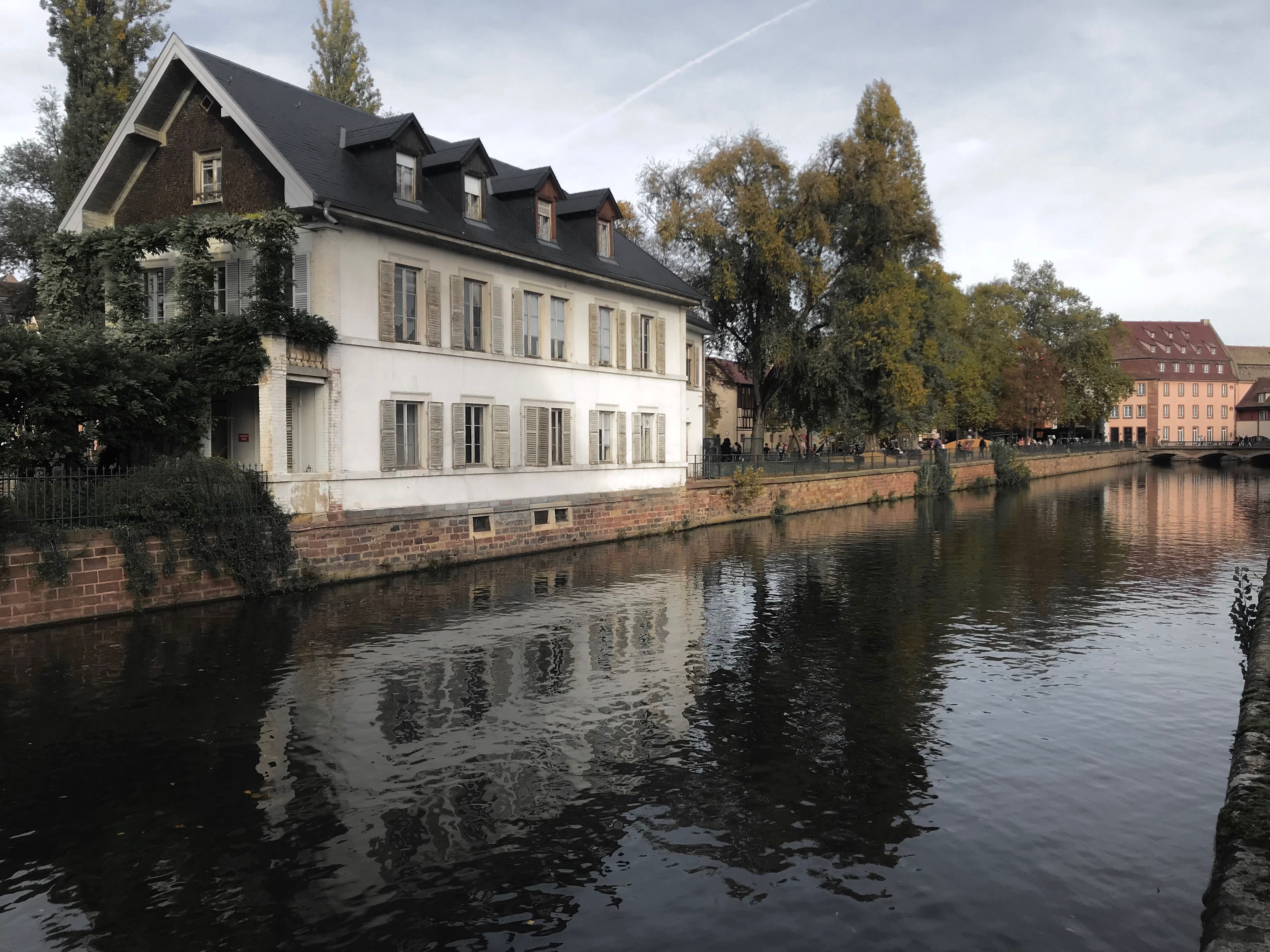 Serene canal scene with a charming house reflecting in the water in France.