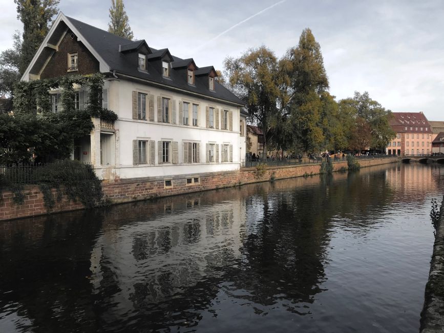 Serene canal scene with a charming house reflecting in the water in France.