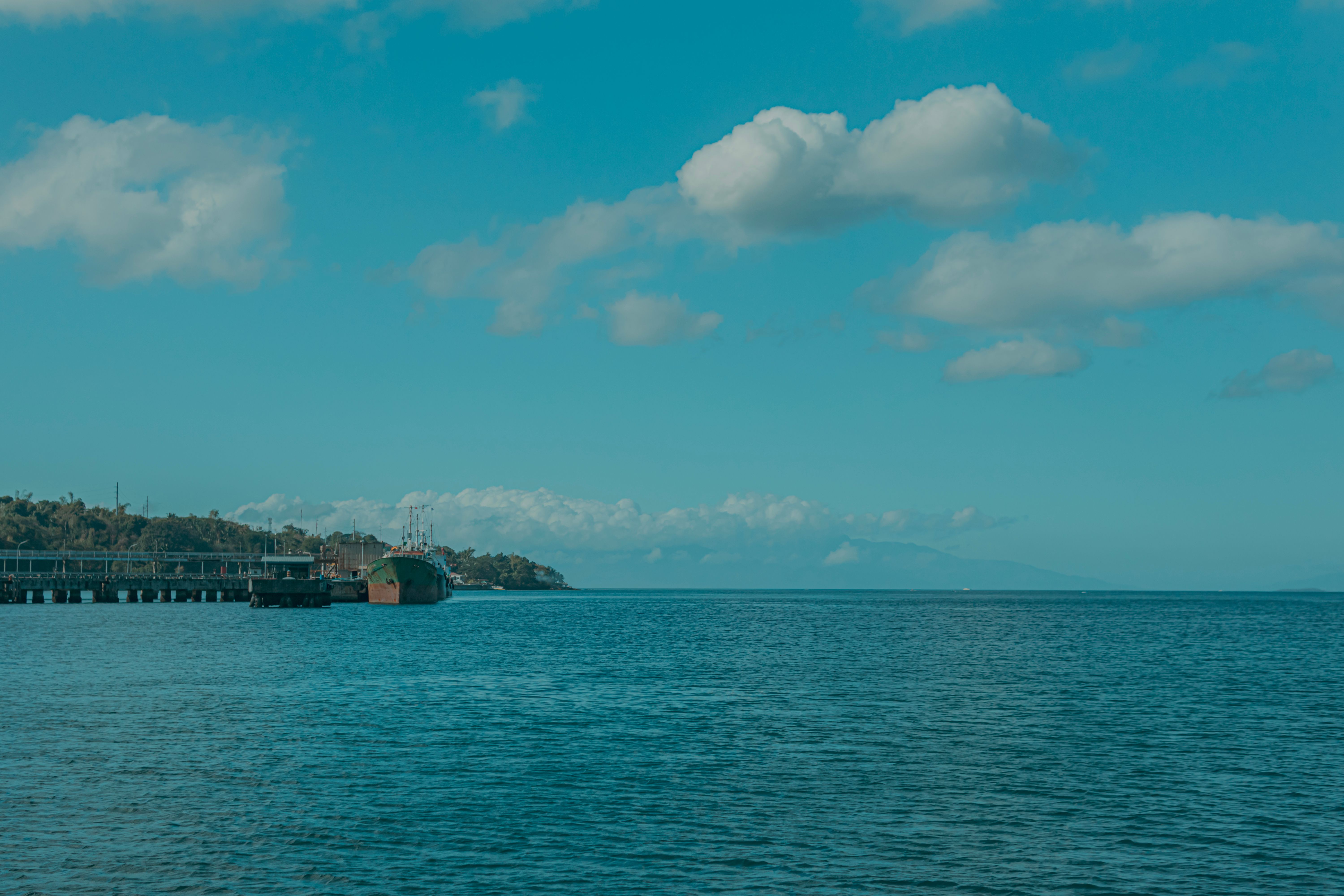 Serene harbour scene with a pier under bright blue Maui sky
