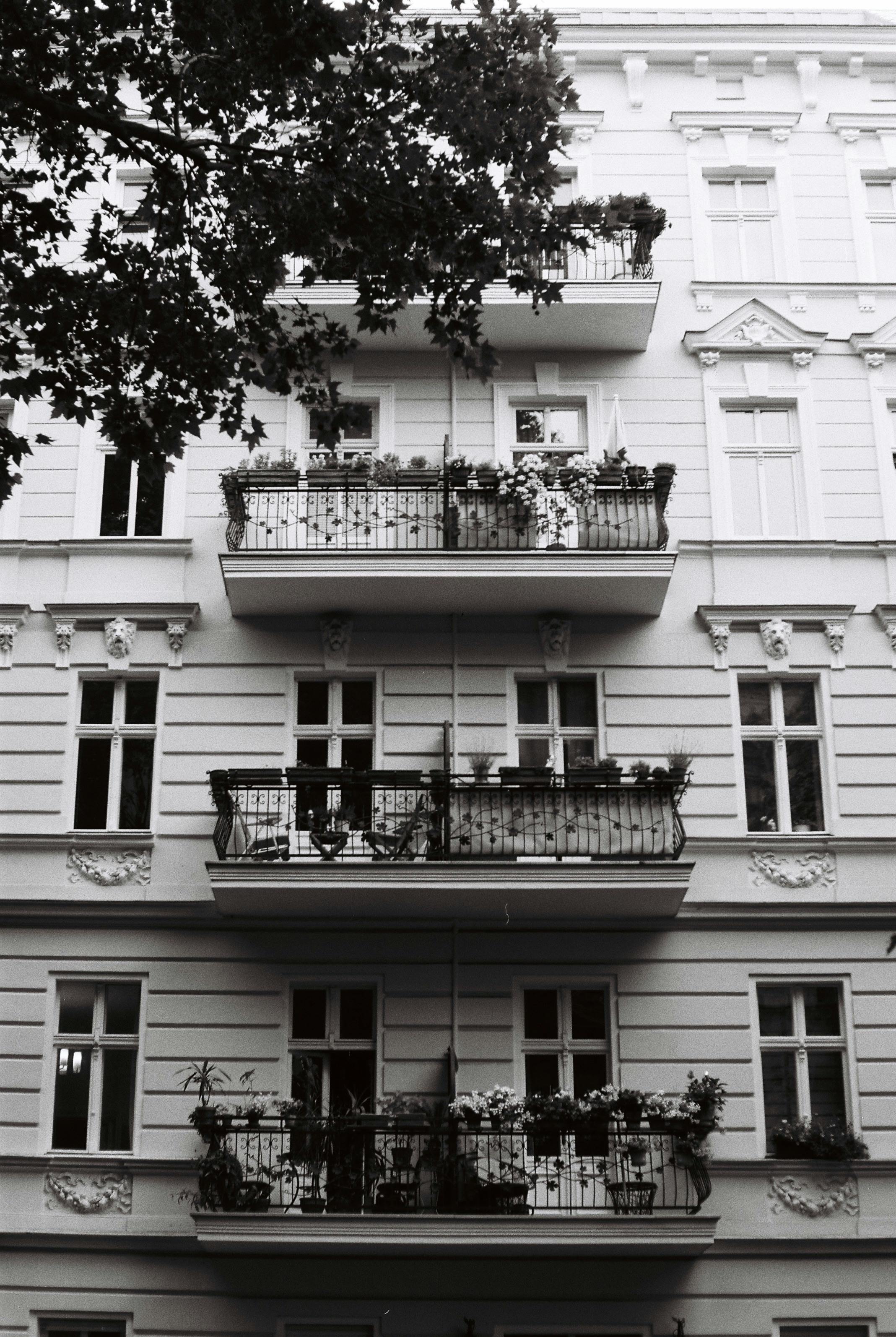 A stylish black and white image showcasing a classic urban apartment building with balconies and ornate architecture.