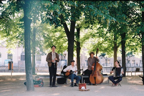 A group of musicians playing music under trees