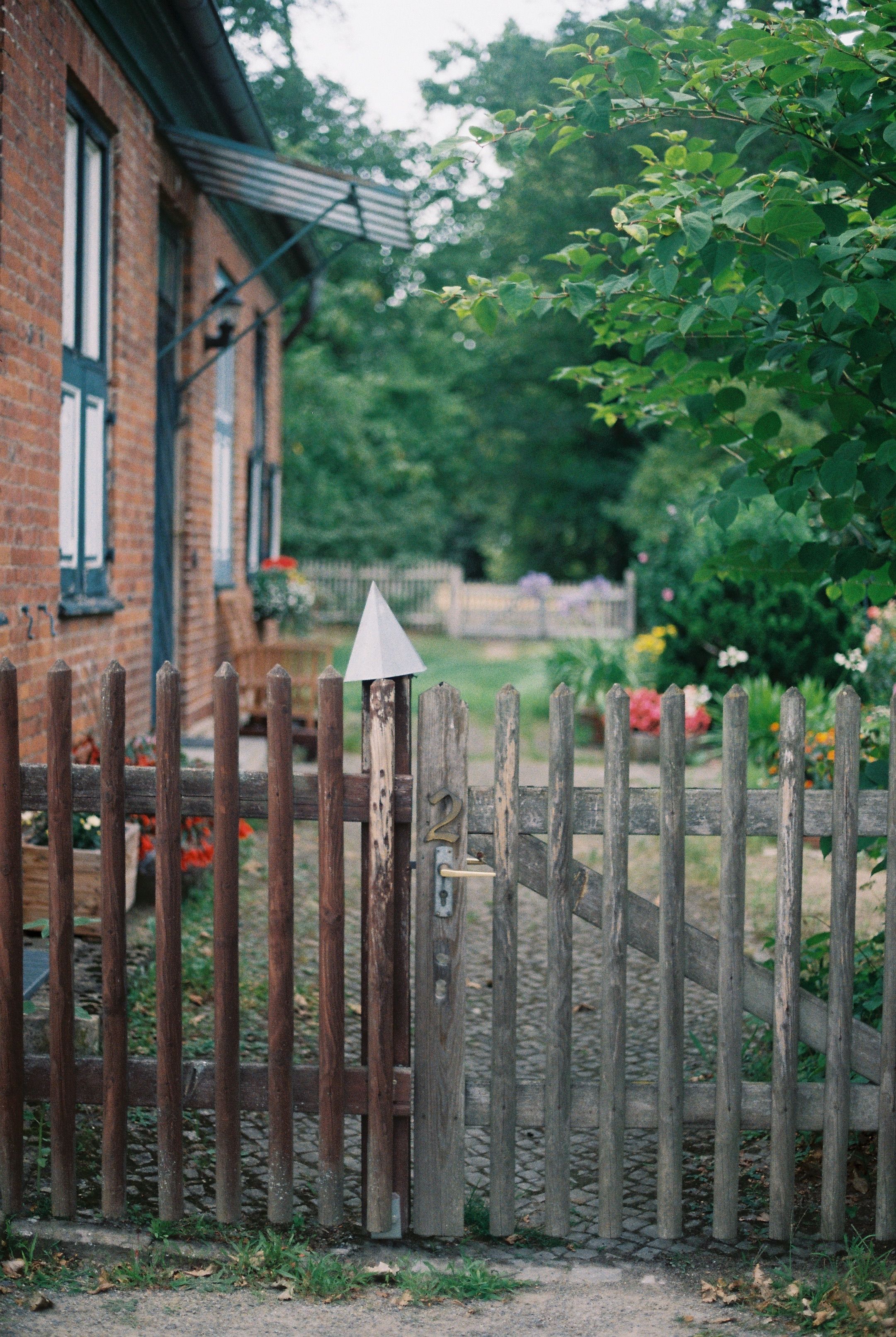 A Wooden Fence and a Brick House in the Countryside · Free Stock Photo