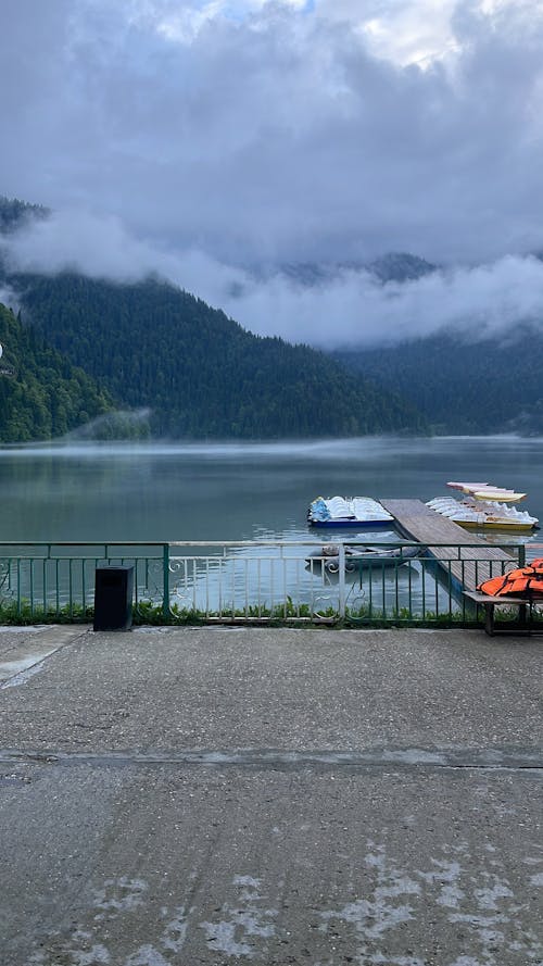 A dock with boats and a mountain in the background