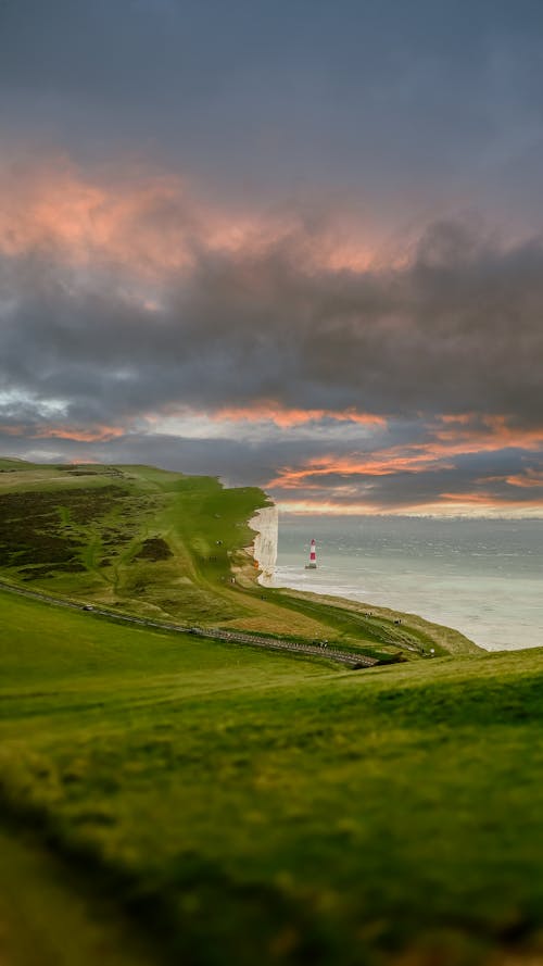 A sunset over the sea and grassy hills