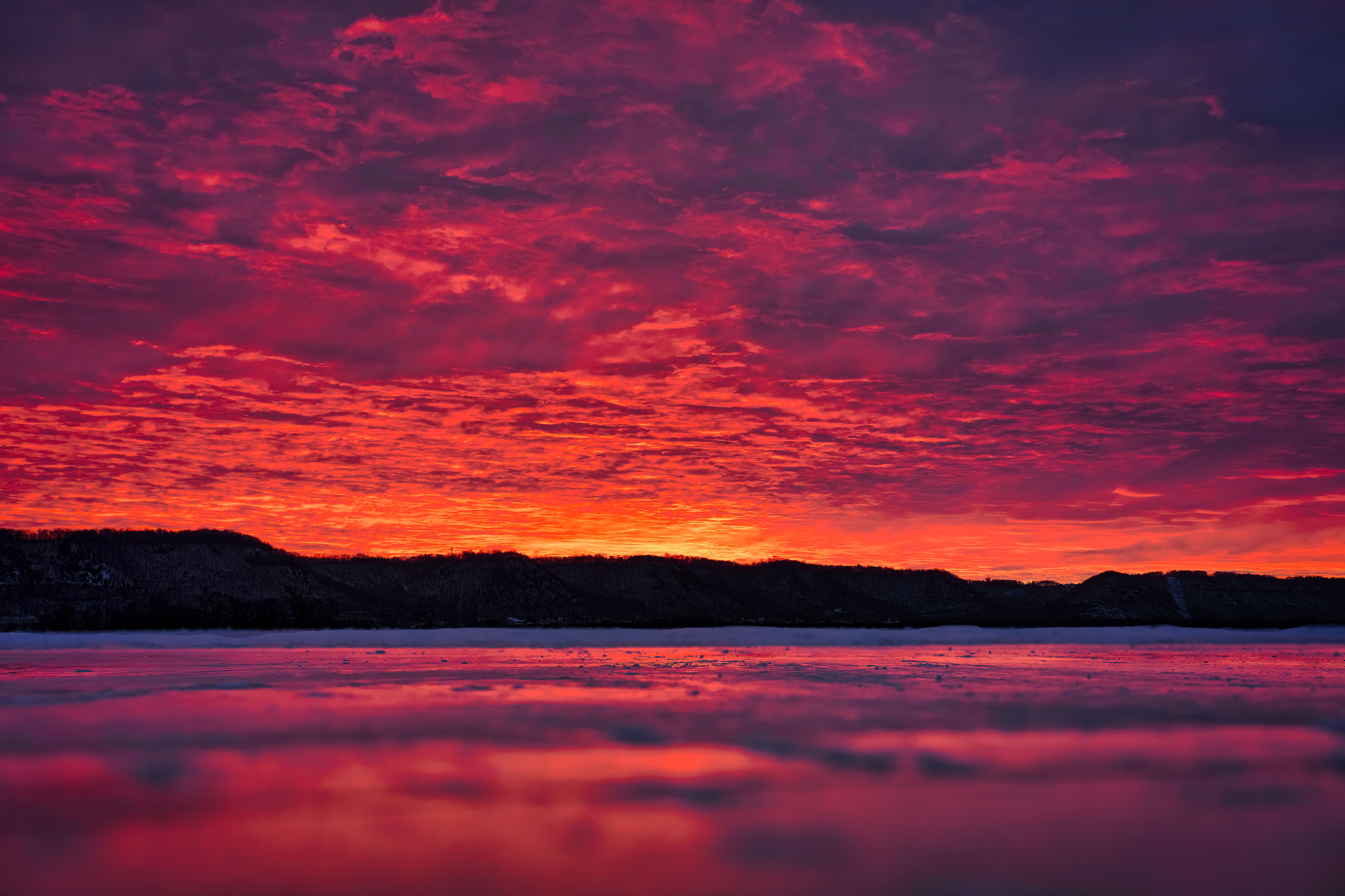 A red sky with clouds and mountains in the background · Free Stock Photo