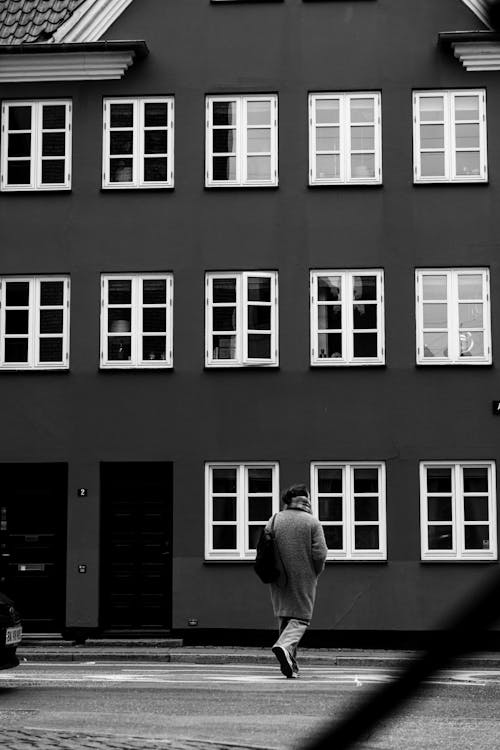 A man walking past a row of buildings