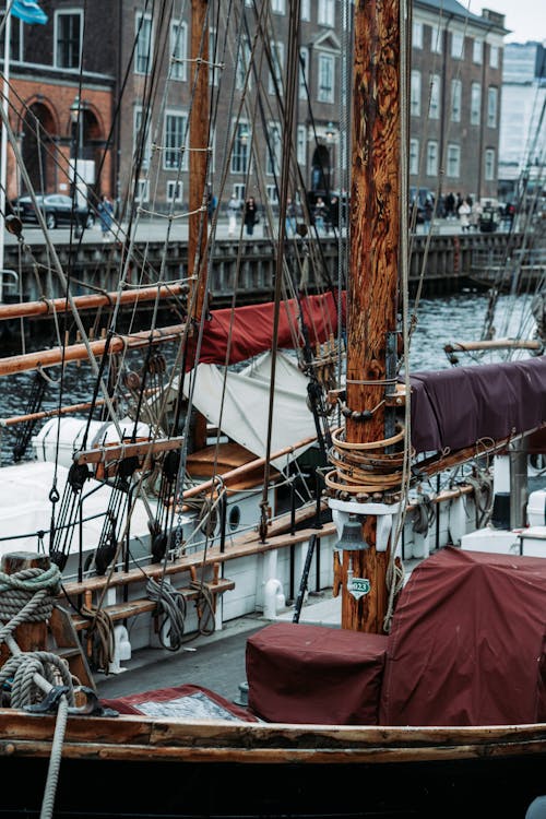 A boat docked in a harbor with a sail