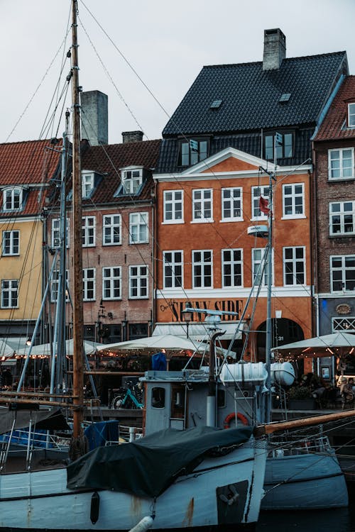 A boat is docked in front of a row of buildings