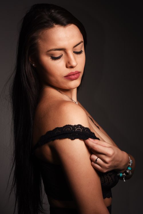 Free An elegant portrait of a brunette woman in lingerie, captured in a moody studio setting. Stock Photo
