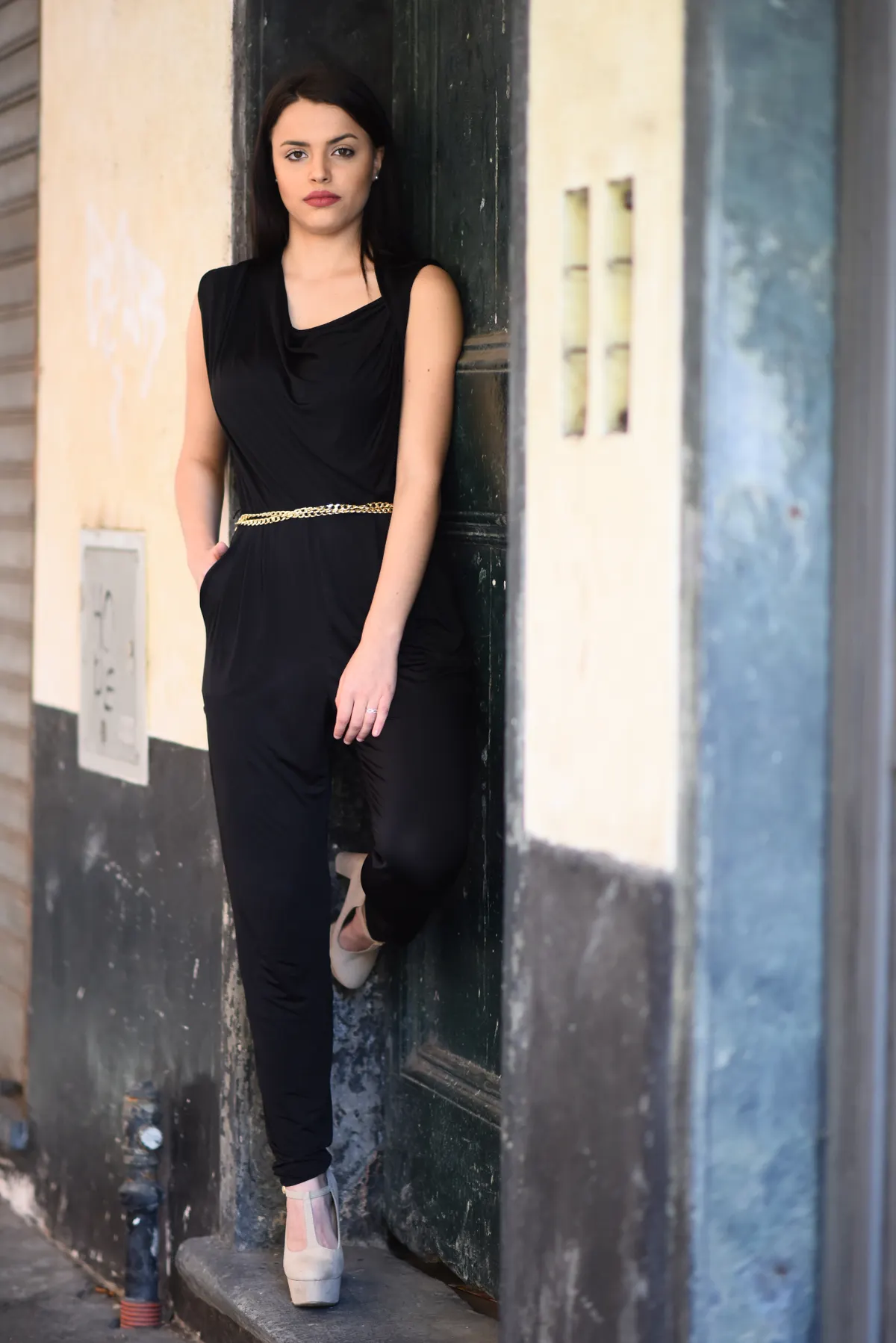 Woman in black jumpsuit, urban backdrop