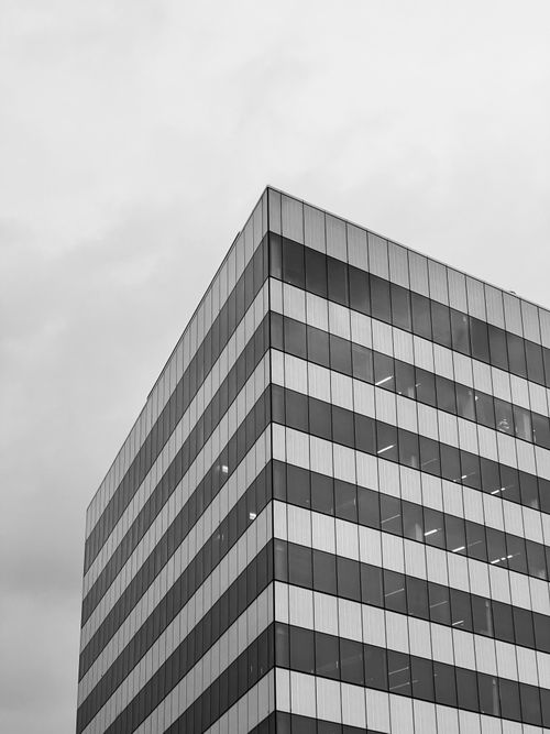 Free Black and white photo of a modern office skyscraper emphasizing minimalistic architecture. Stock Photo