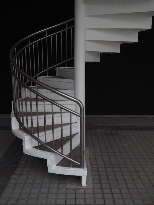 Free Elegant spiral staircase with a minimalist design and strong shadows. Stock Photo