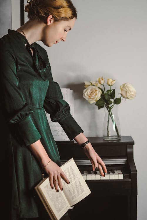 Woman in Green Dress Touching Piano Keys