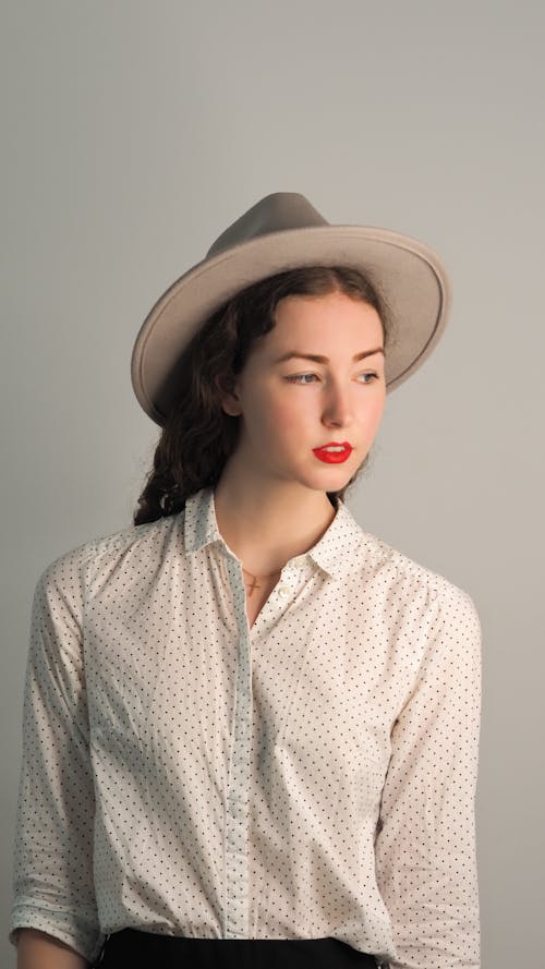 Photo of a Young, Fashionable Woman in a Shirt and a Hat 