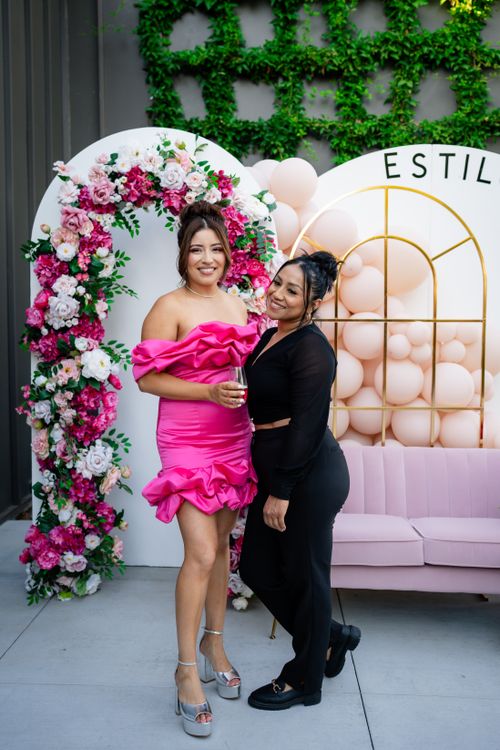 Free Two women celebrating with floral decor, wearing stylish attire at an outdoor event. Stock Photo