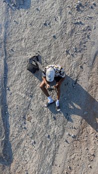 Top-down aerial shot of a person sitting on rocky terrain in Kaduna, Nigeria.