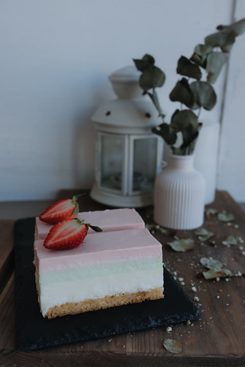 A strawberry and cream cake on a black plate