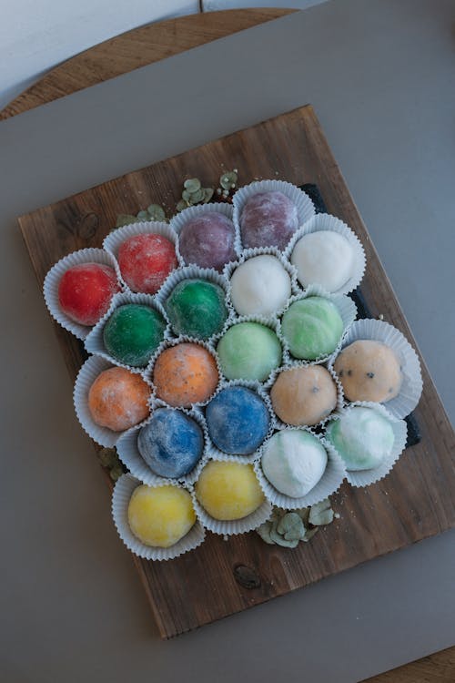A tray of colorful balls on a wooden board