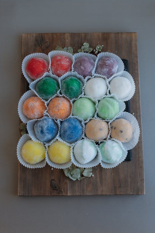 A tray of colorful balls on a wooden board