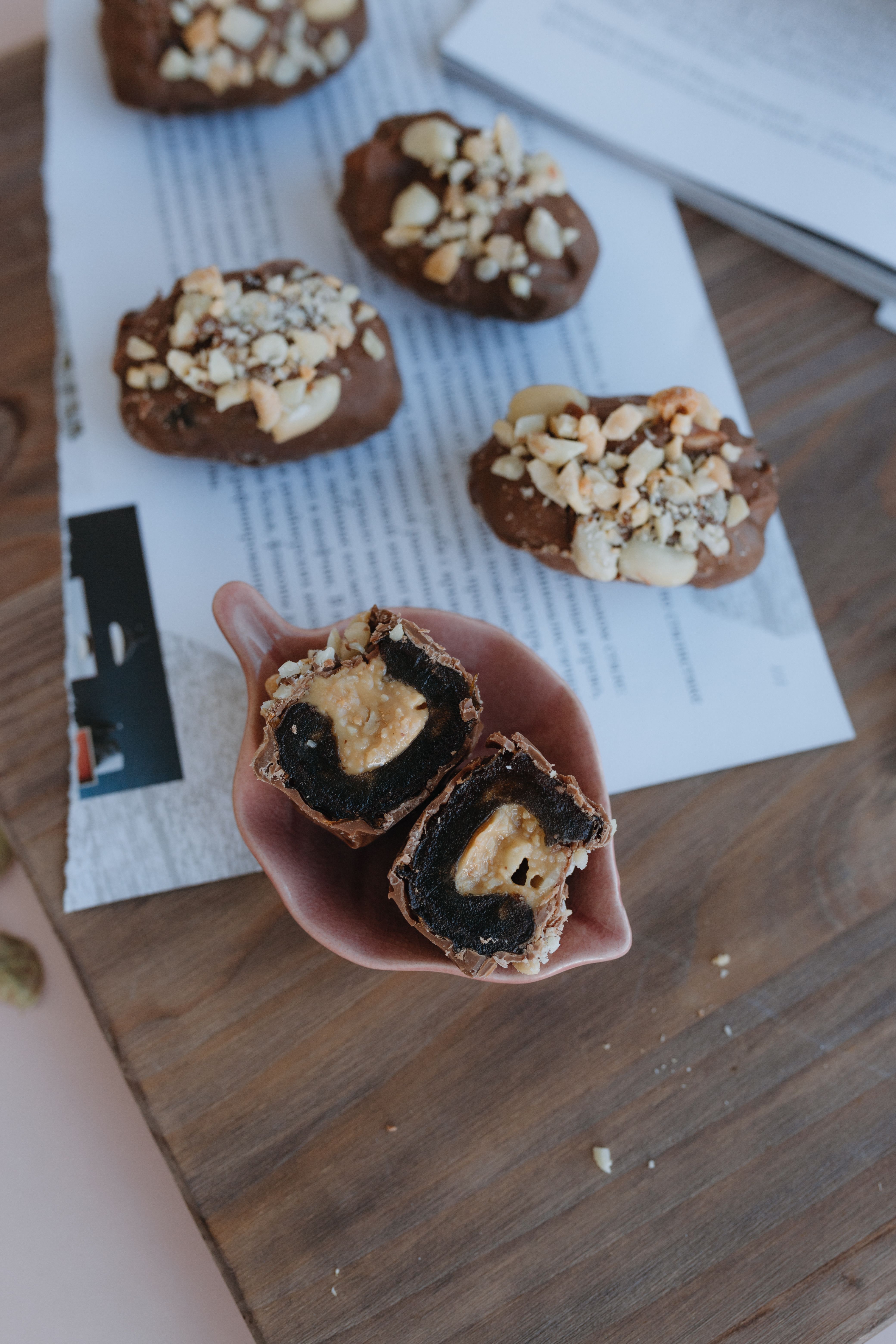 A chocolate covered cookie with nuts on top