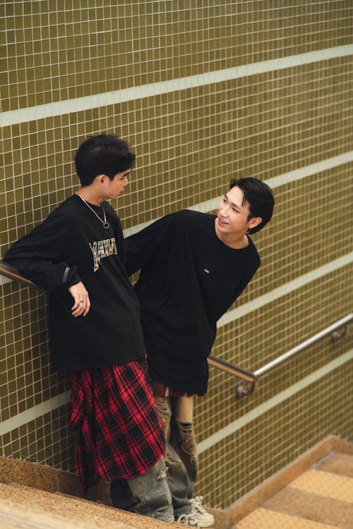 Two young men standing on the stairs of a building