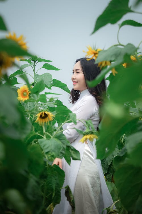 Woman in White Dress Standing on Sunflower Field