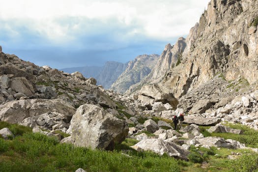A hiker navigates the rugged terrain of the Rocky Mountains near Pinedale, WY, showcasing nature's grandeur.