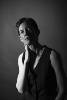 Stylish black and white portrait of a woman in a studio setting with an elegant pose.