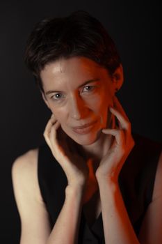 Elegant studio portrait of a woman in Berlin with soft lighting and a black background.