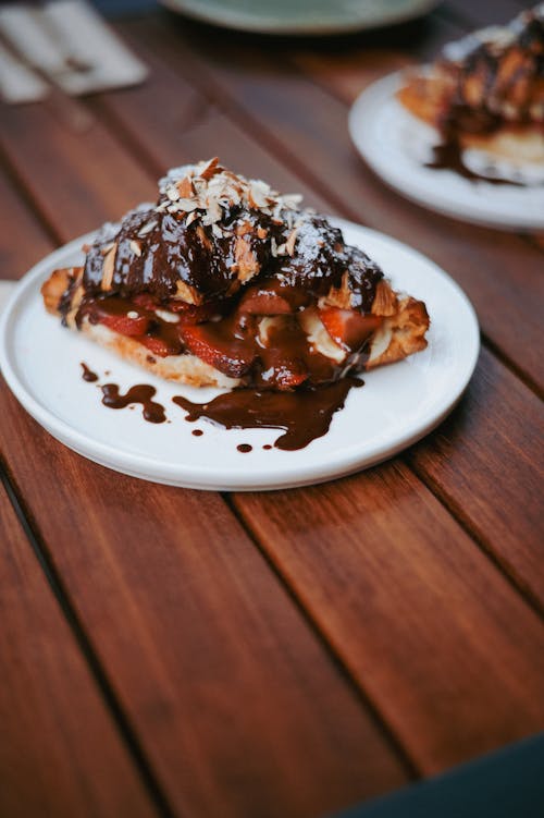 A pastry with chocolate sauce and nuts on top