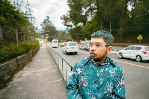 Young man with blue hair walking down the sidewalk
