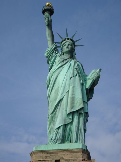 Free The iconic Statue of Liberty photographed from below against a clear blue sky in New York City. Stock Photo