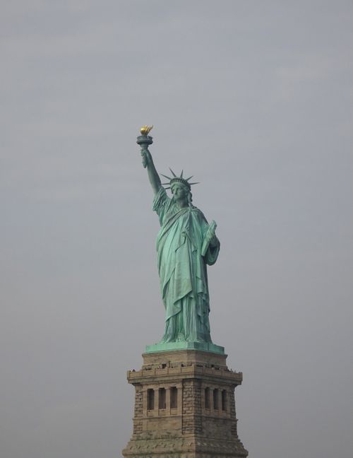 Free Iconic Statue of Liberty against the New York City skyline, a symbol of freedom and democracy. Stock Photo