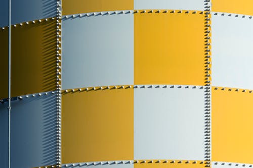 A yellow and white striped wall with metal studs