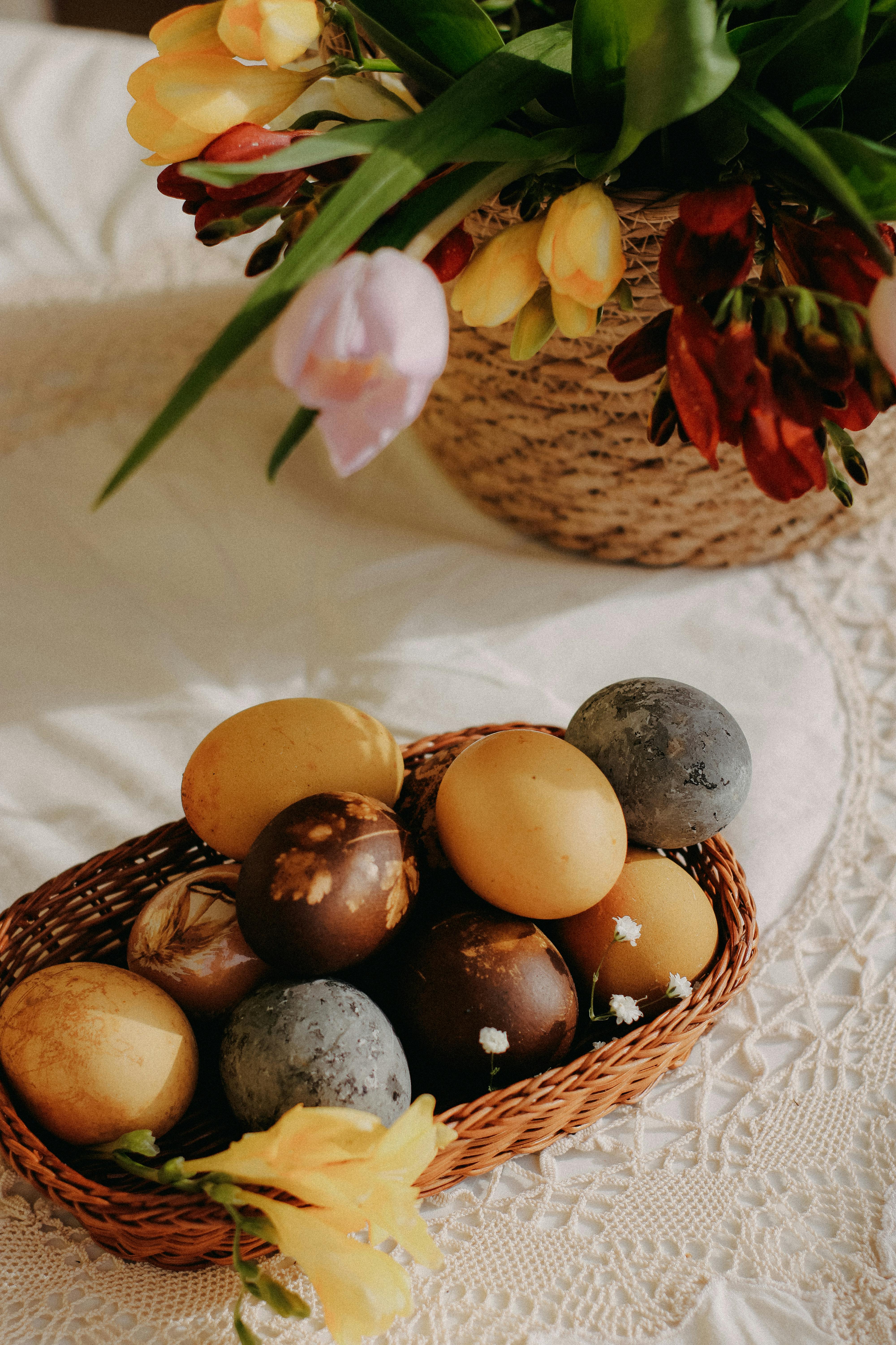 Colorful dyed Easter eggs in a basket with tulips, perfect for spring celebrations.