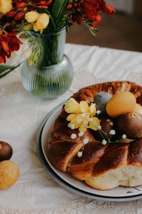 Free Festive Easter cake decorated with eggs and spring flowers on a table. Stock Photo