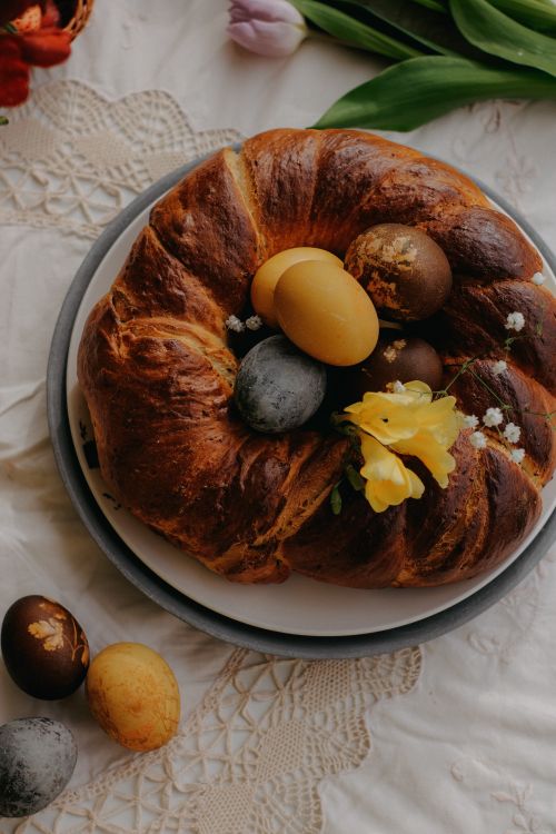 Free Top view of Easter bread with dyed eggs and flowers on a decorated rustic table setting. Stock Photo