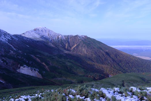 Breathtaking landscape of snowcapped mountains and lush valleys in Hokkaido, Japan.
