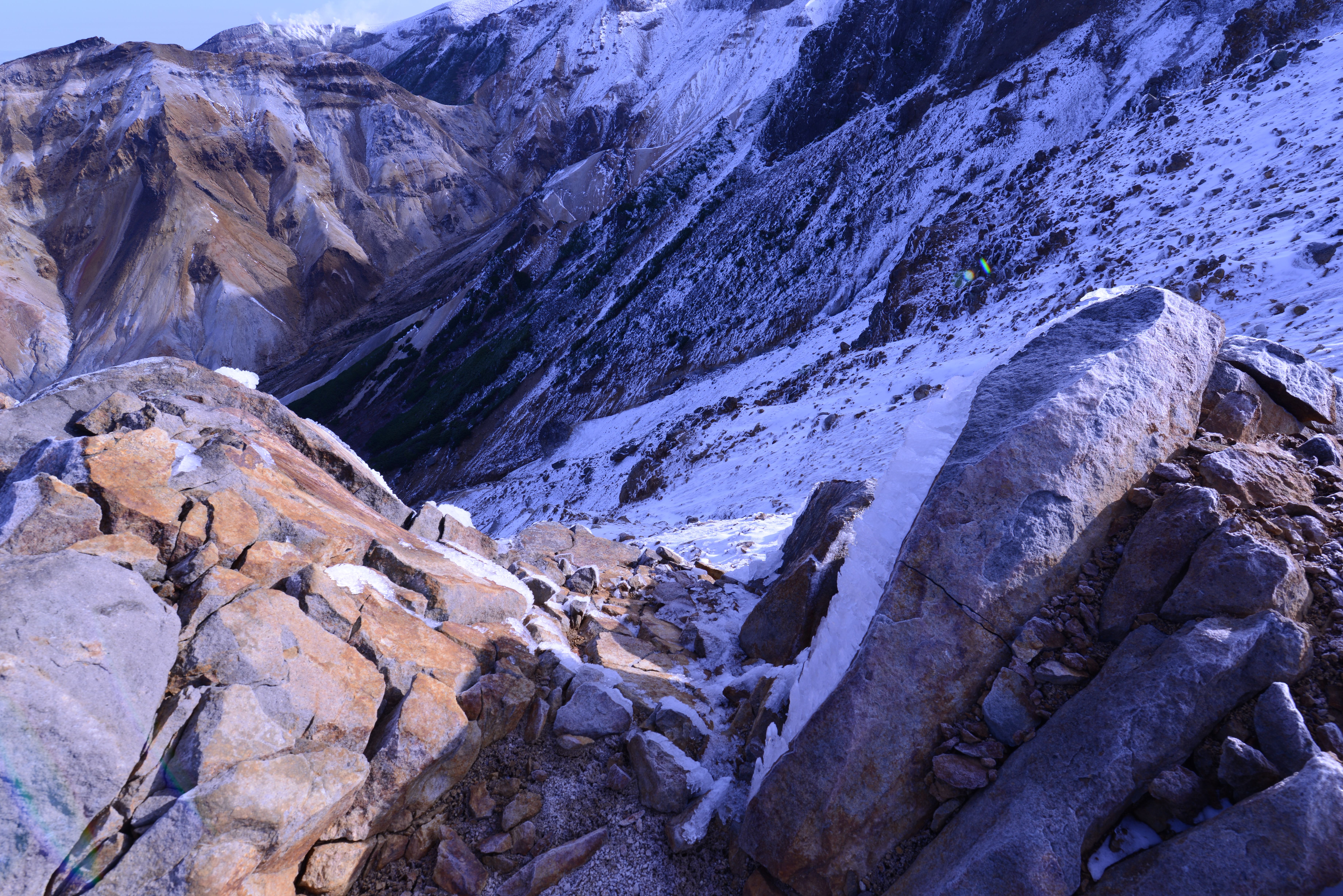 Breathtaking snowy mountain landscape in Hokkaido's rugged terrain, featuring steep rocky slopes.