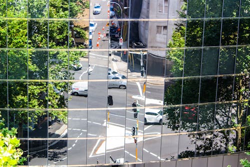 Reflections of street crossing in glass mirror windows of building