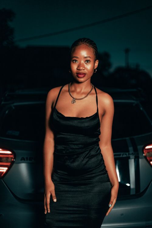 Young Woman in a Black Dress Standing near a Car · Free Stock Photo