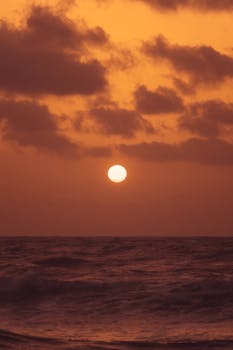 A beautiful sunset over the ocean in Akumal, México, with vibrant colors and dramatic clouds.