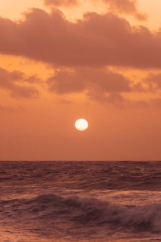 Dramatic sunset with vibrant colors over the ocean at Akumal Beach, Mexico.