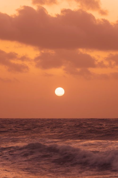 Free Dramatic sunset with vibrant colors over the ocean at Akumal Beach, Mexico. Stock Photo