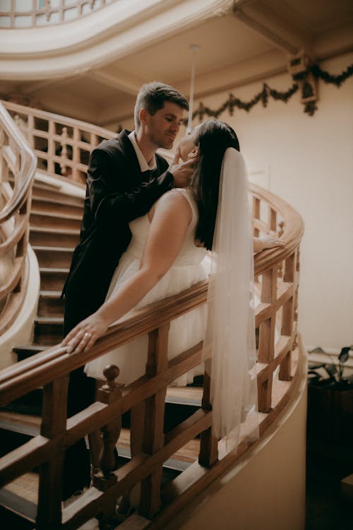 A bride and groom standing on the stairs