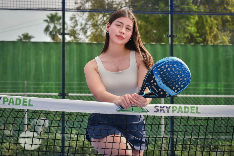 Confident player holding a padel racket on an outdoor court